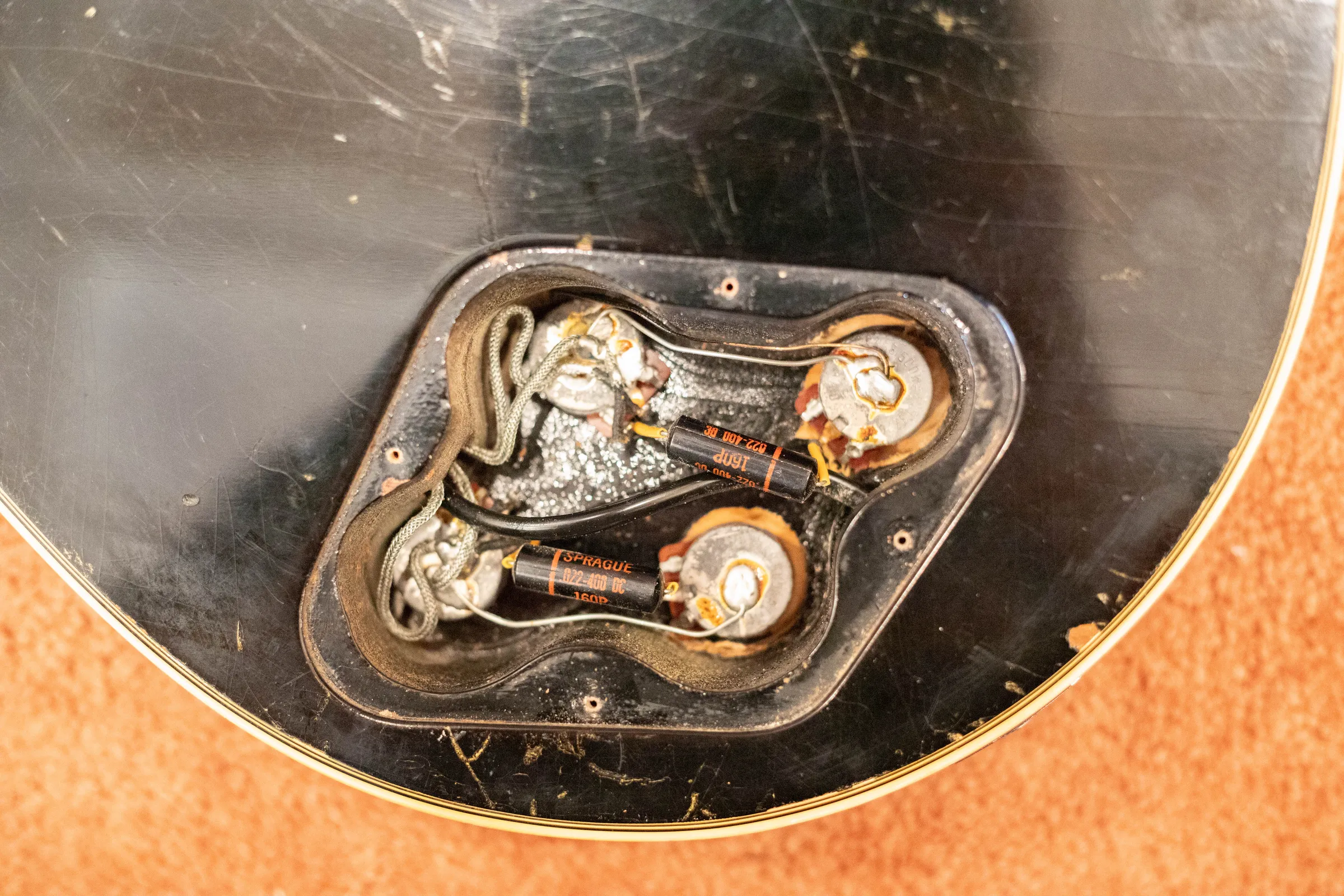 Open control cavity of a 1970 Gibson Les Paul Custom showing pots, wiring and capacitors