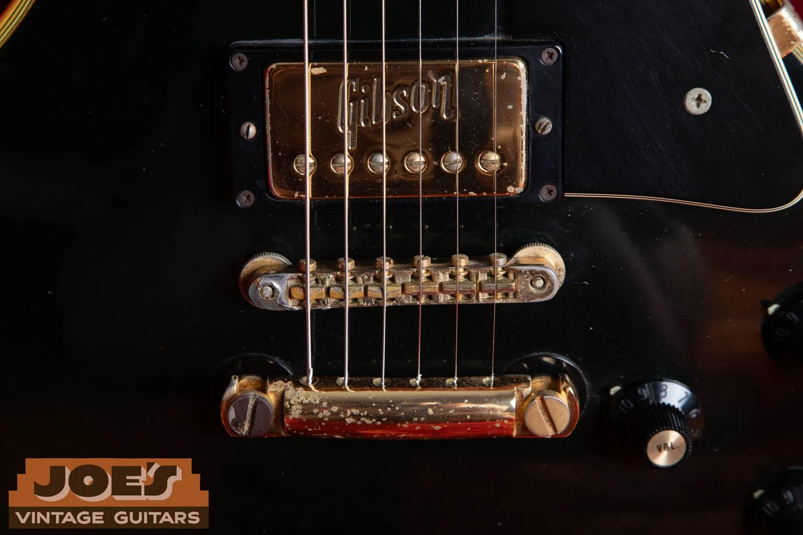 Embossed Gibson logo on a gold pickup cover on a 1972 Les Paul Custom