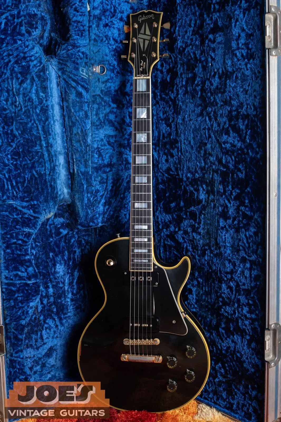 Full front of a black 1973 Gibson Les Paul Custom 1954-style reissue in its case