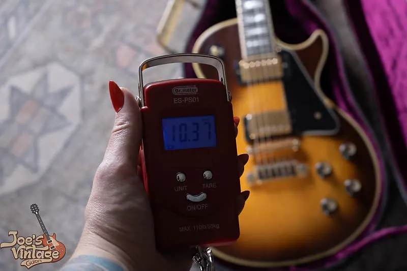 Digital scale displaying 10.37 lb beside a 1977 Sunburst Gibson Les Paul Custom