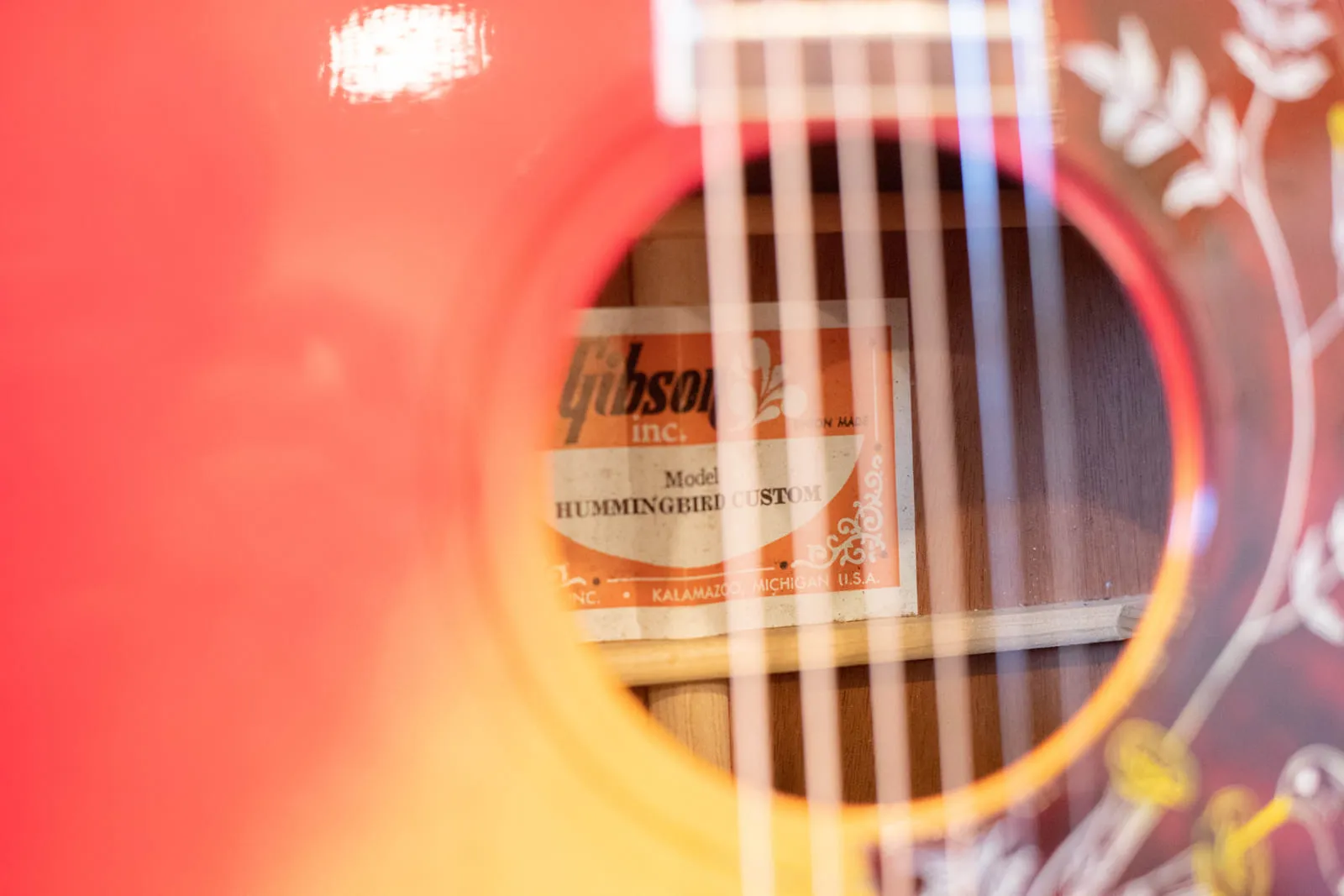 The rectangular orange and white Gibson label inside a 1979 Hummingbird reading Gibson Inc, Model HUMMINGBIRD CUSTOM, Kalamazoo Michigan USA.