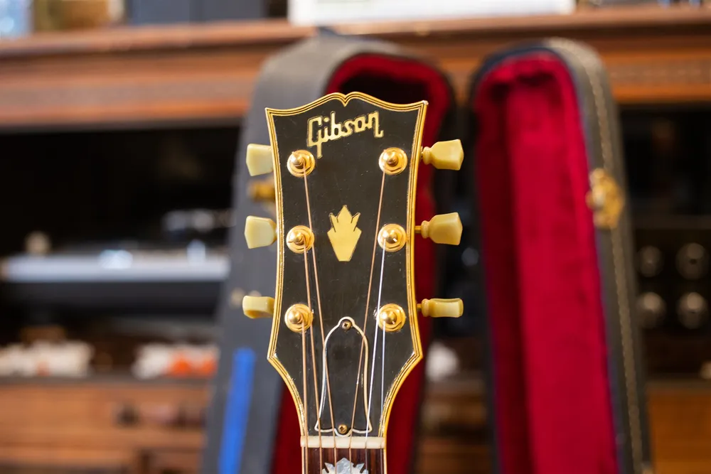 Bound front headstock of a 1986 Gibson J-200 with logo and crown