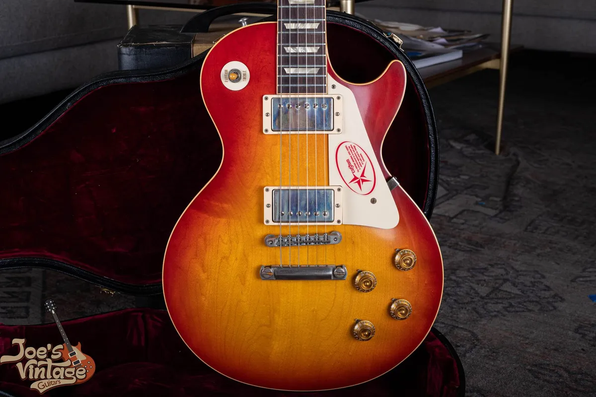 2011 Gibson R8 reissue with a plain sunburst top, humbuckers and gold knobs; not a vintage 1958 Les Paul