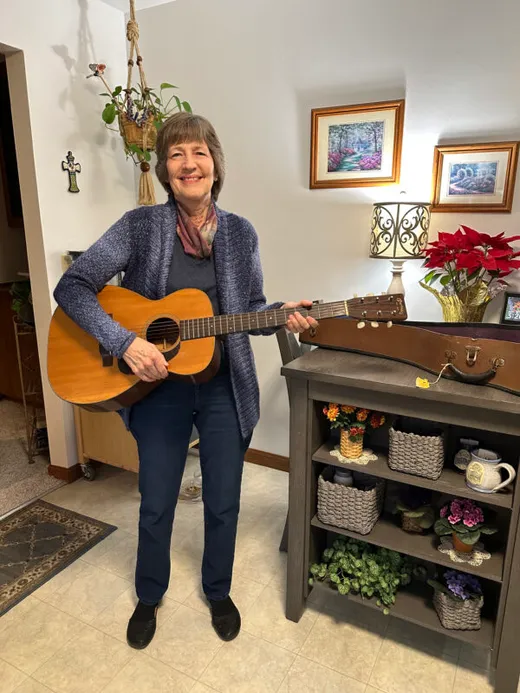 A Martin owner holding her vintage acoustic guitar