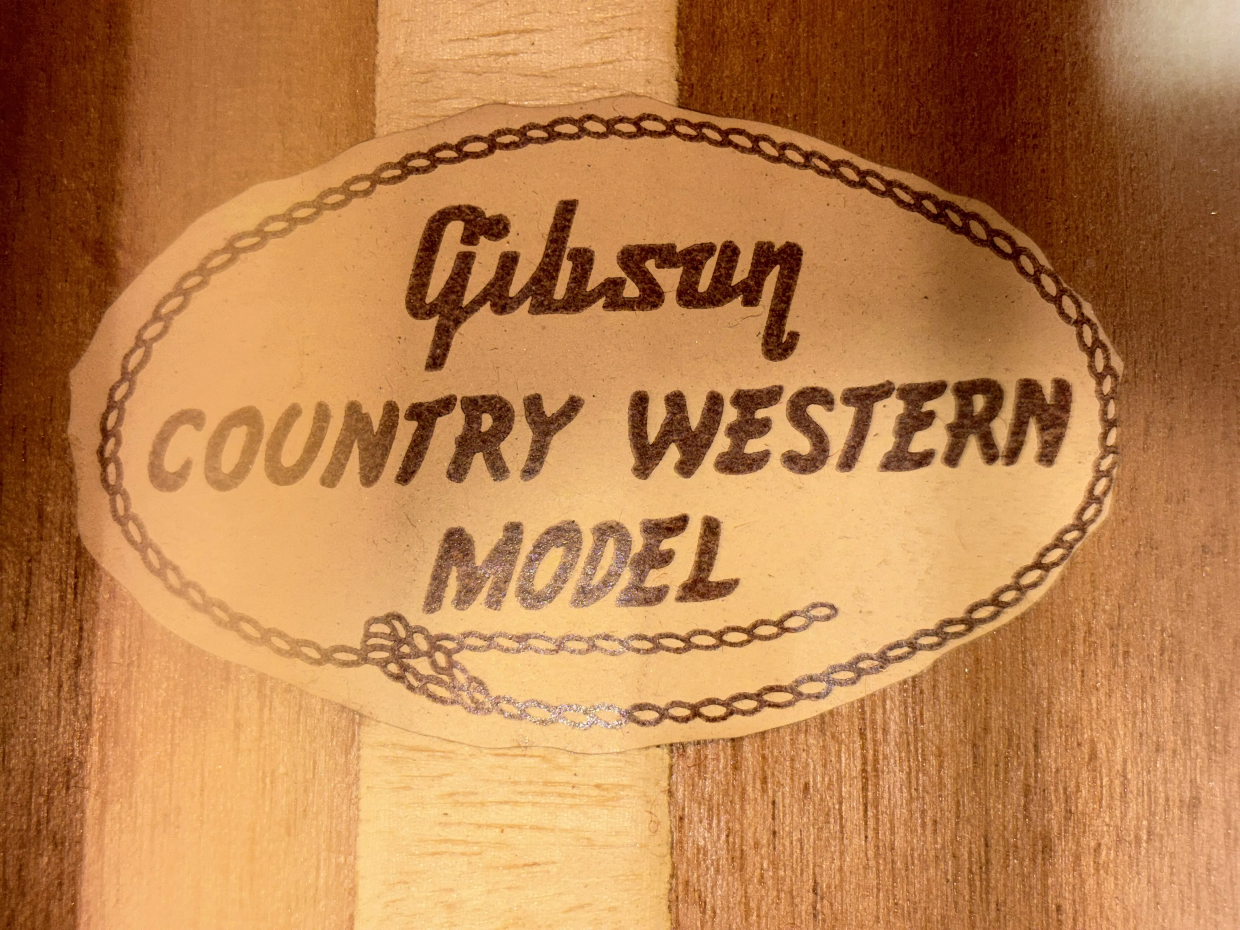 Interior Gibson label reading Country Western Model with a rope-pattern border