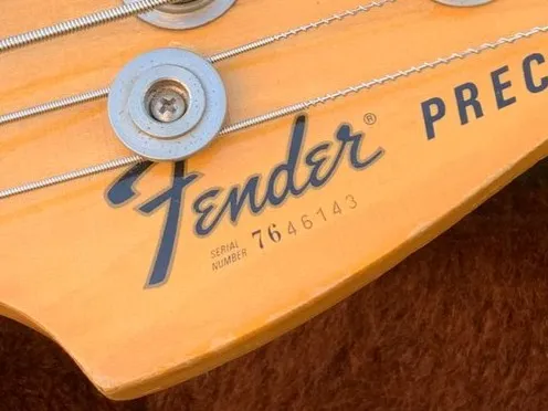 Fender 76-prefix serial number on front of headstock, seen on guitars made in 1976 when Fender transitioned from neck plate to headstock serials