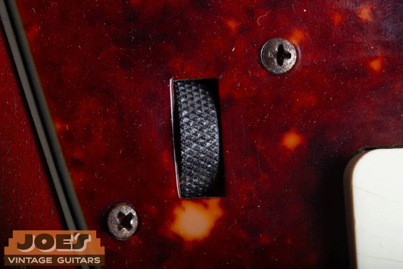 The chrome-edged rhythm circuit roller wheel on a Fender Jazzmaster upper bout