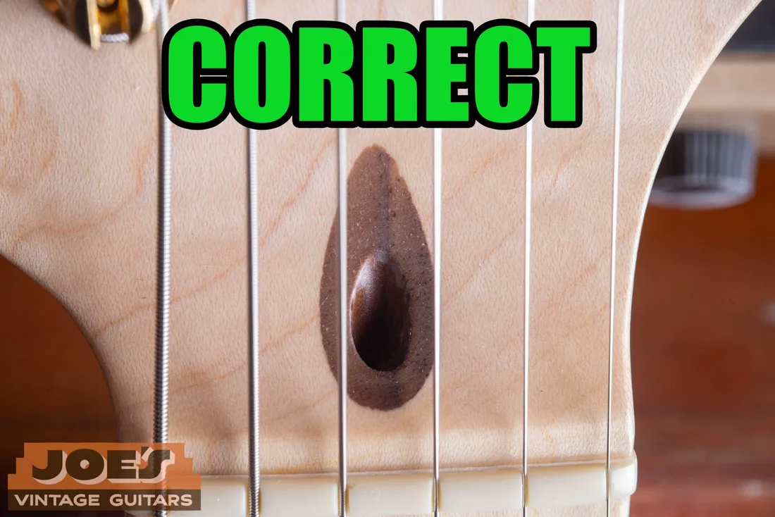 Dark walnut plug surrounding a Fender headstock truss rod opening