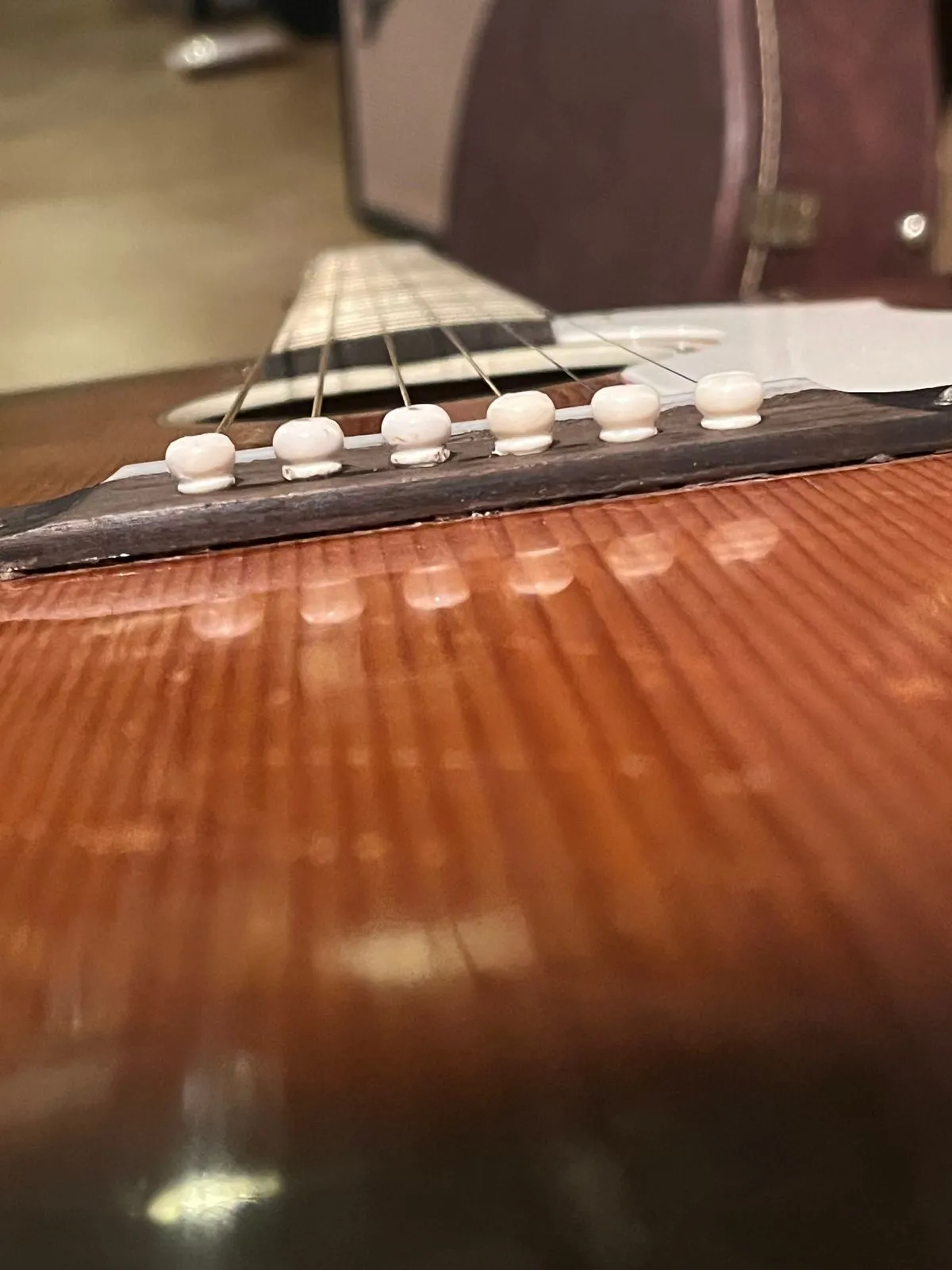 Low angle view of a Silvertone H621 acoustic guitar showing a narrow gap beneath the bridge