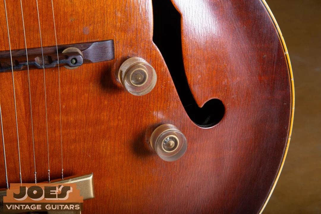 Two tall clear unnumbered control knobs on a vintage Gibson archtop guitar