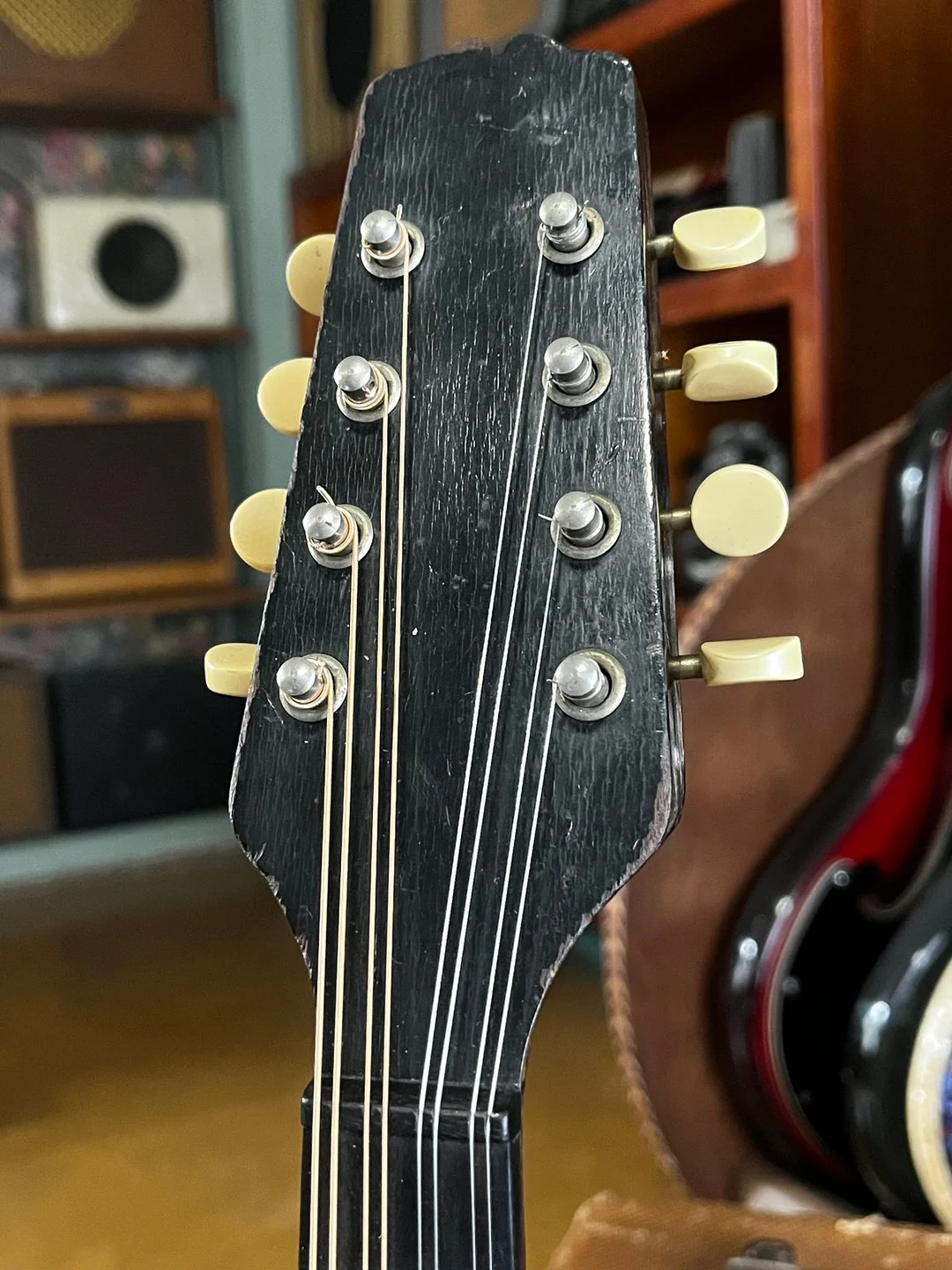 Early Gibson eight-string mandolin peghead with no logo on the black face