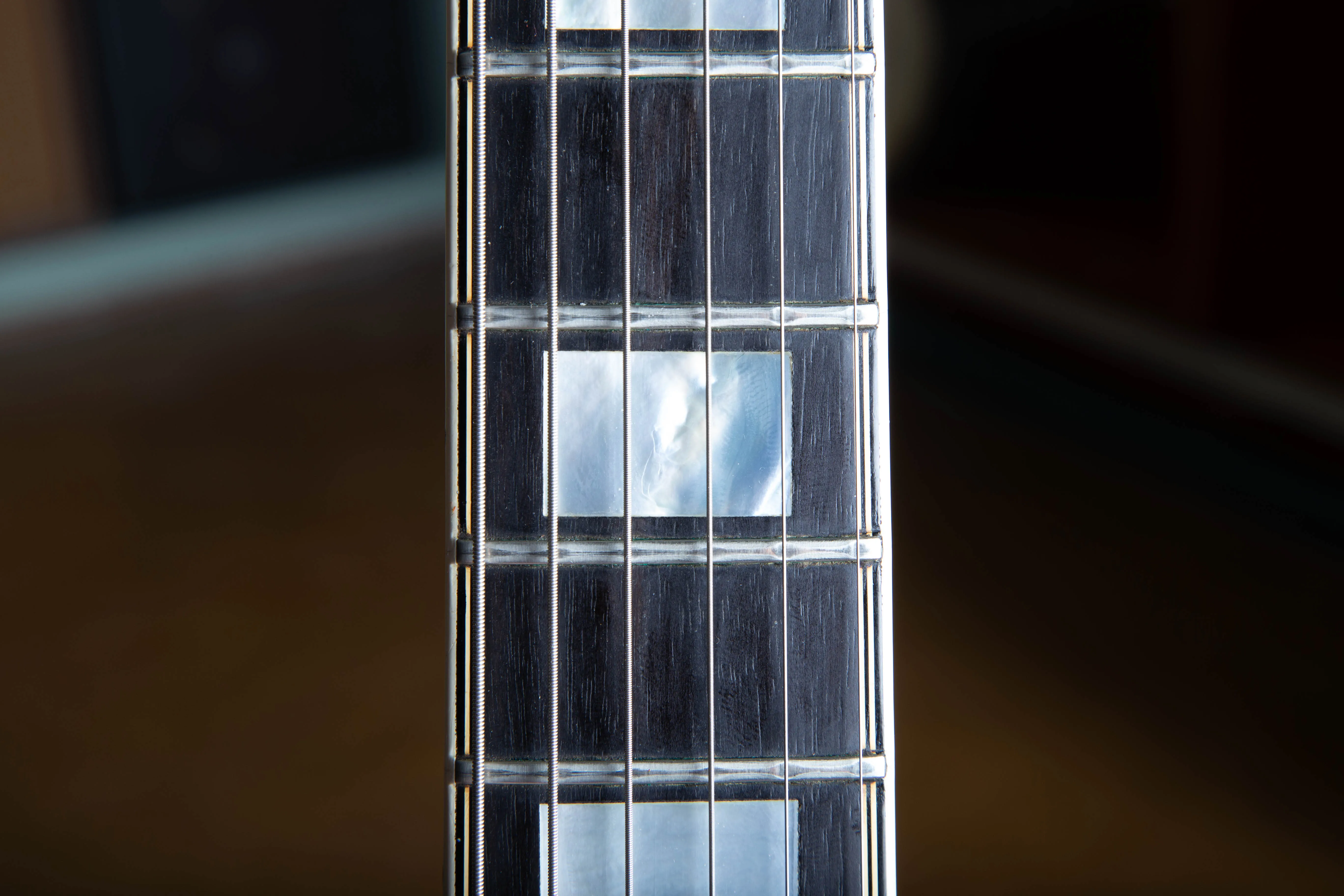 Rectangular block inlay and multiple binding lines on an L-5 CES fingerboard.