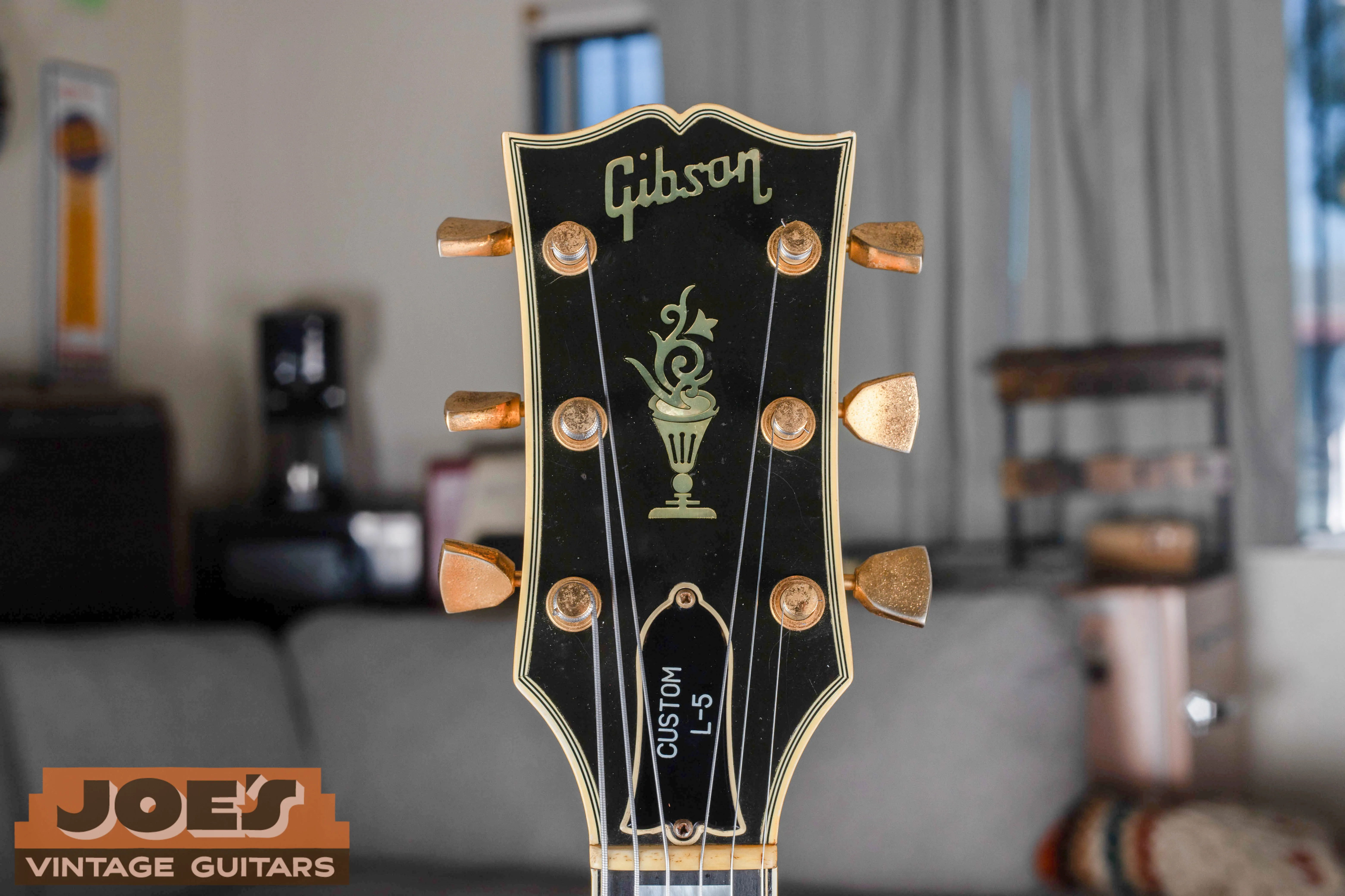 Bound Gibson headstock with flowerpot inlay, gold-colored tuners and a Custom L-5 truss rod cover.