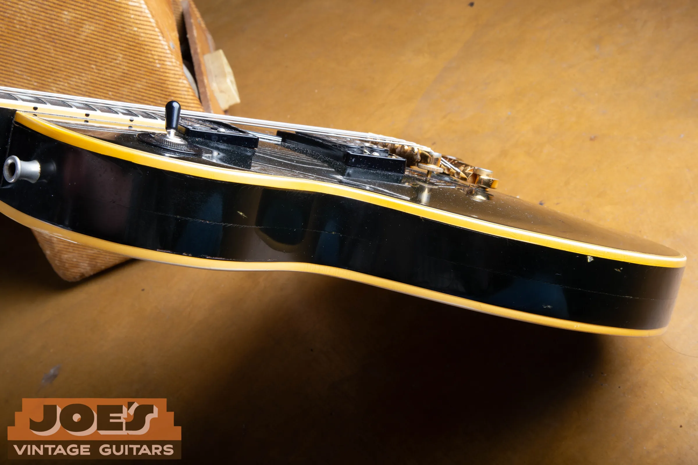 Black Les Paul body edge with a faint horizontal line through the side finish