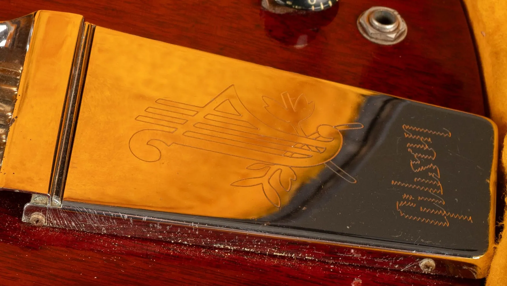 Engraved lyre and Gibson lettering on an SG Maestro vibrato cover