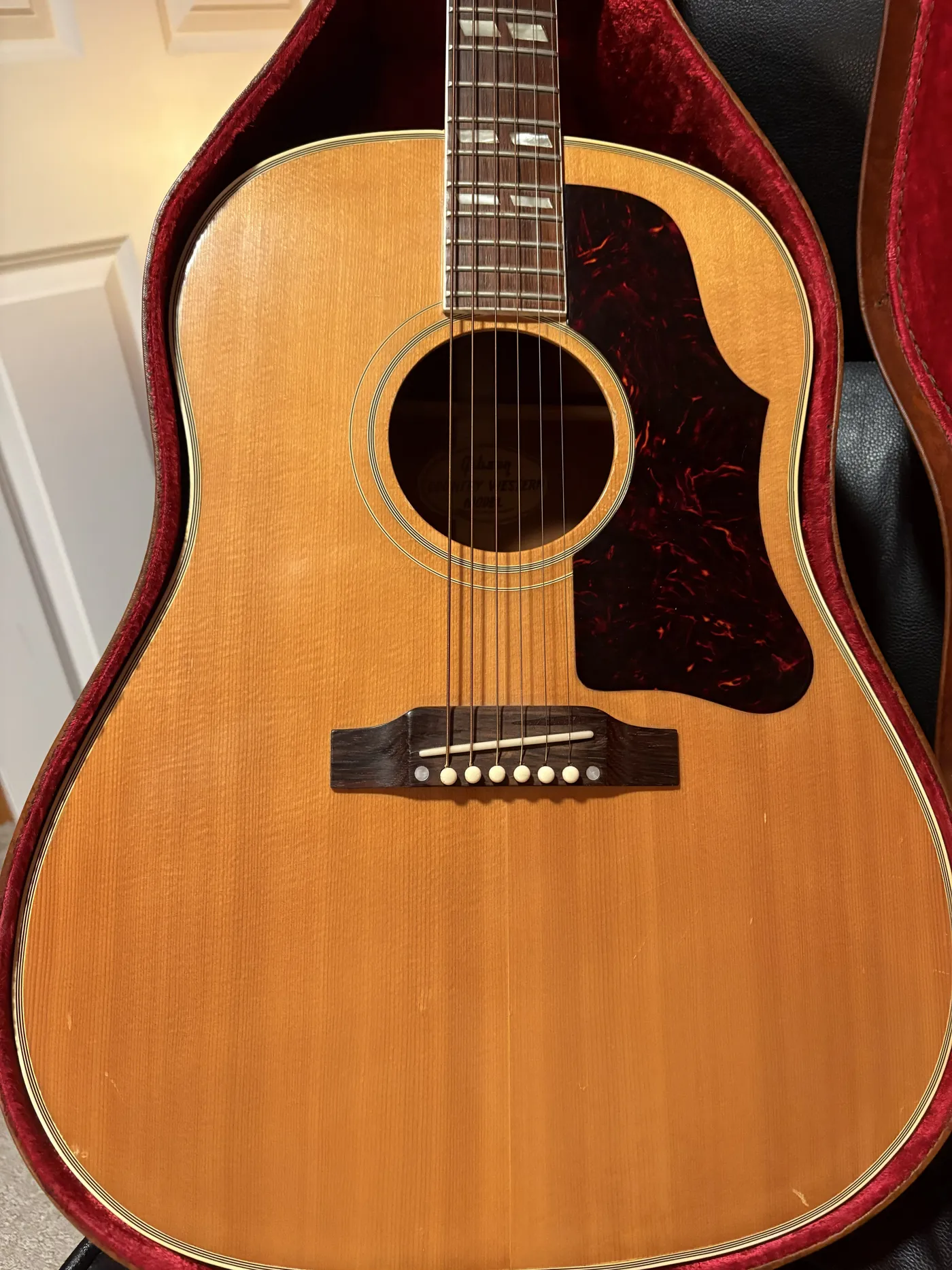 1957 Gibson Country Western with slope shoulders, natural top, split parallelogram inlays and a large pickguard