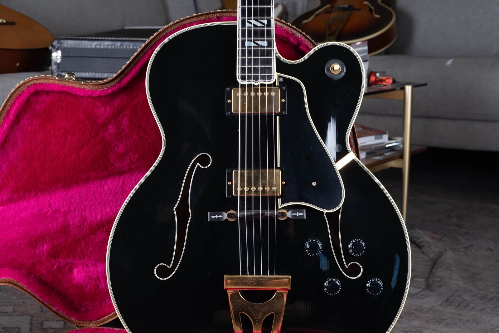 A 1990s Gibson Super 400 in black finish, in a magenta-lined case.