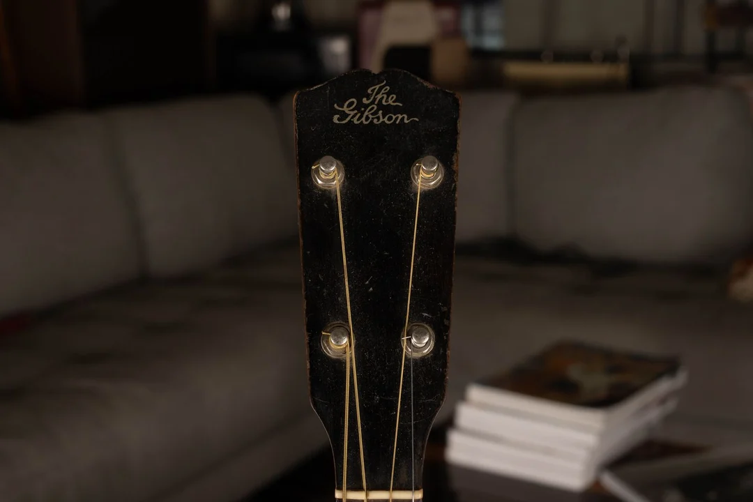Vintage four-string Gibson instrument with The Gibson written straight across in thin script