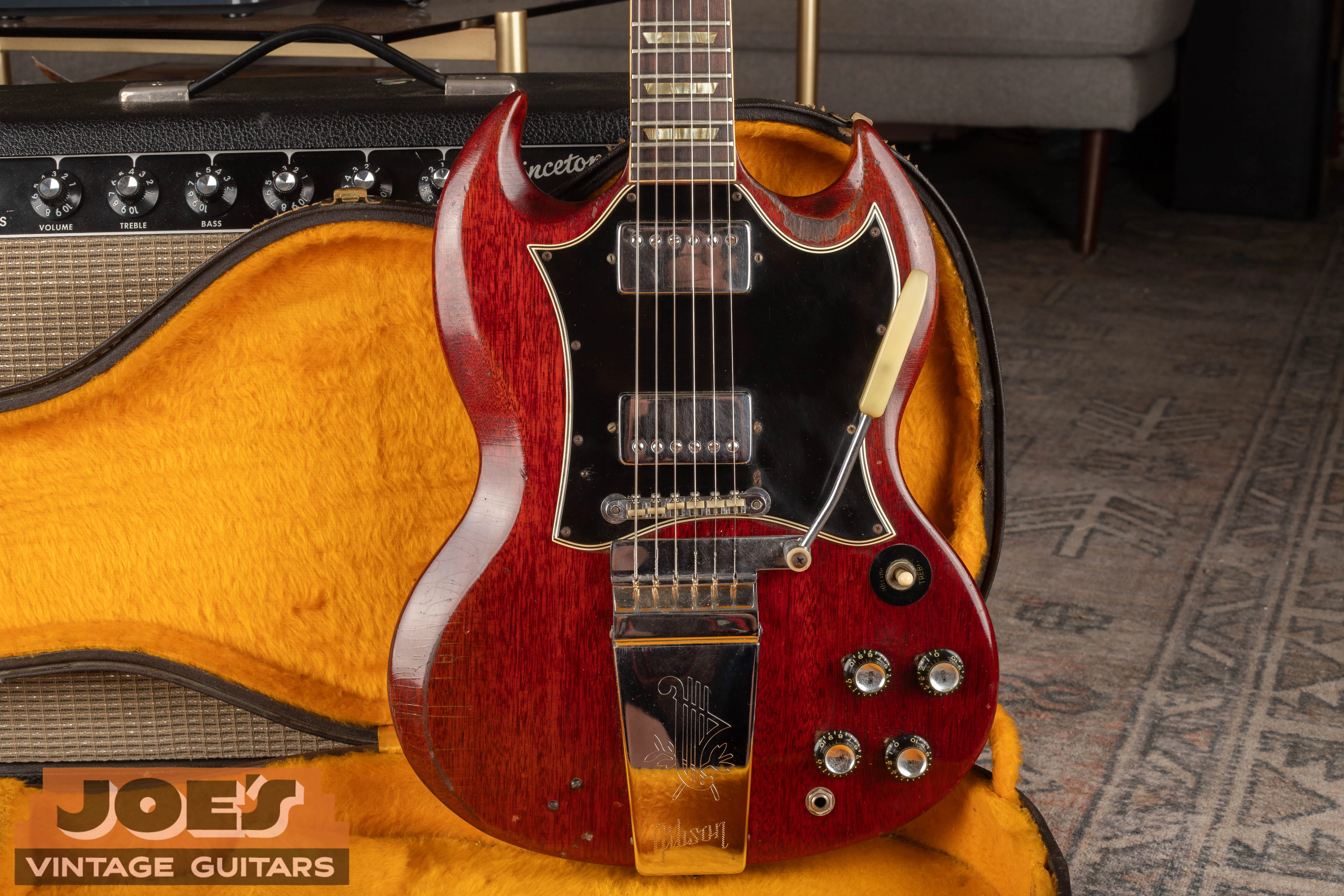 Cherry SG Standard with a large black pickguard, two covered humbuckers and a long lyre Vibrola