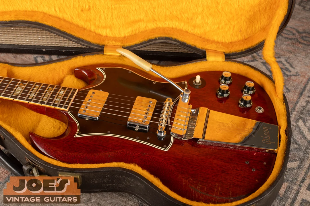 Long Maestro vibrato and engraved Lyre cover on an SG Standard in a yellow-lined case