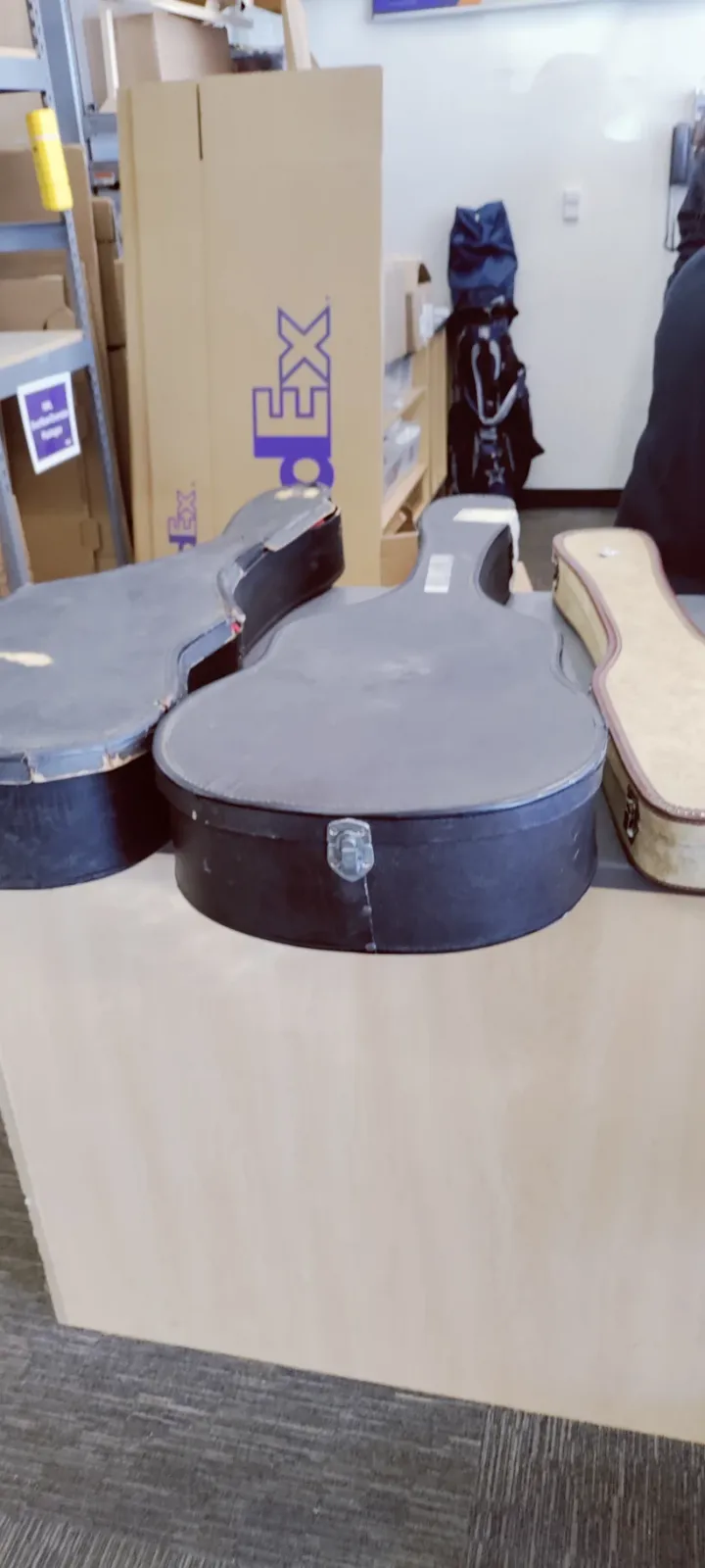 Two Martin guitars and a lap steel in their cases on a FedEx counter