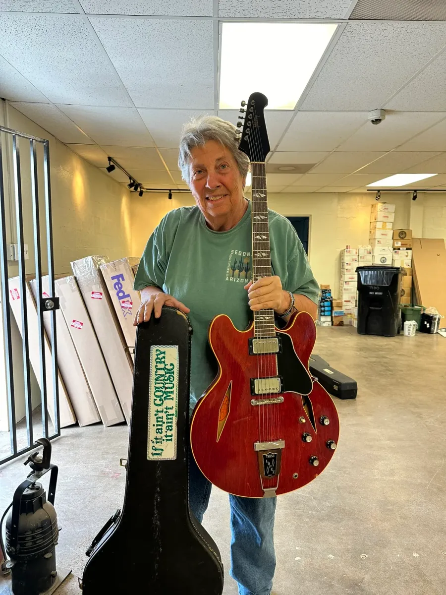 Mesa seller holding a cherry 1966 Gibson Trini Lopez inside Joe's Vintage Guitars