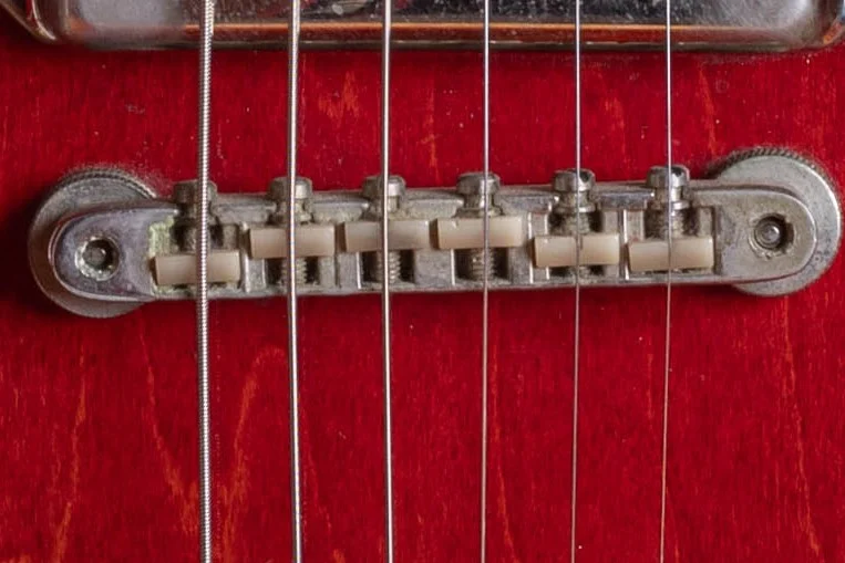 Close view of cream nylon saddles in a vintage Gibson ABR-1 bridge