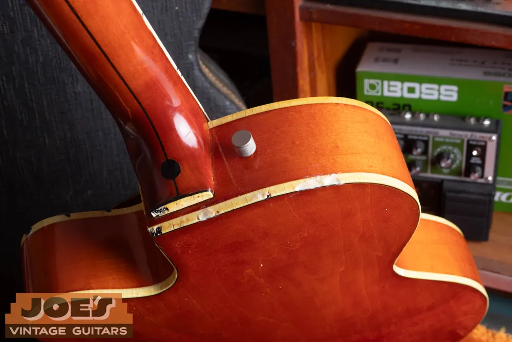 Cracked and missing binding along the side of an orange Gretsch 6120