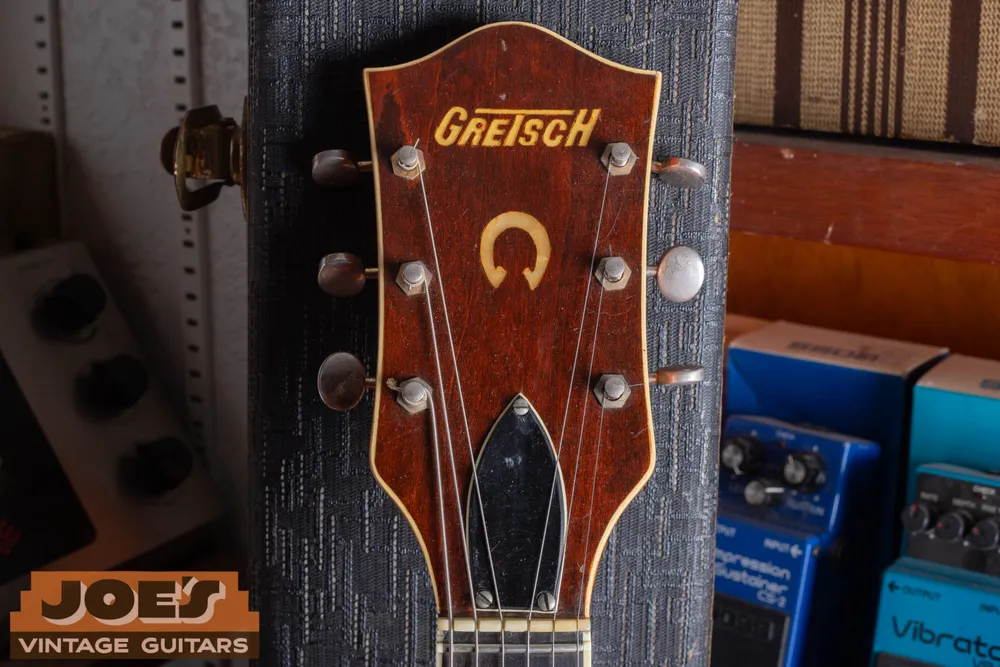 Front of an orange 6120 headstock with Gretsch logo and horseshoe