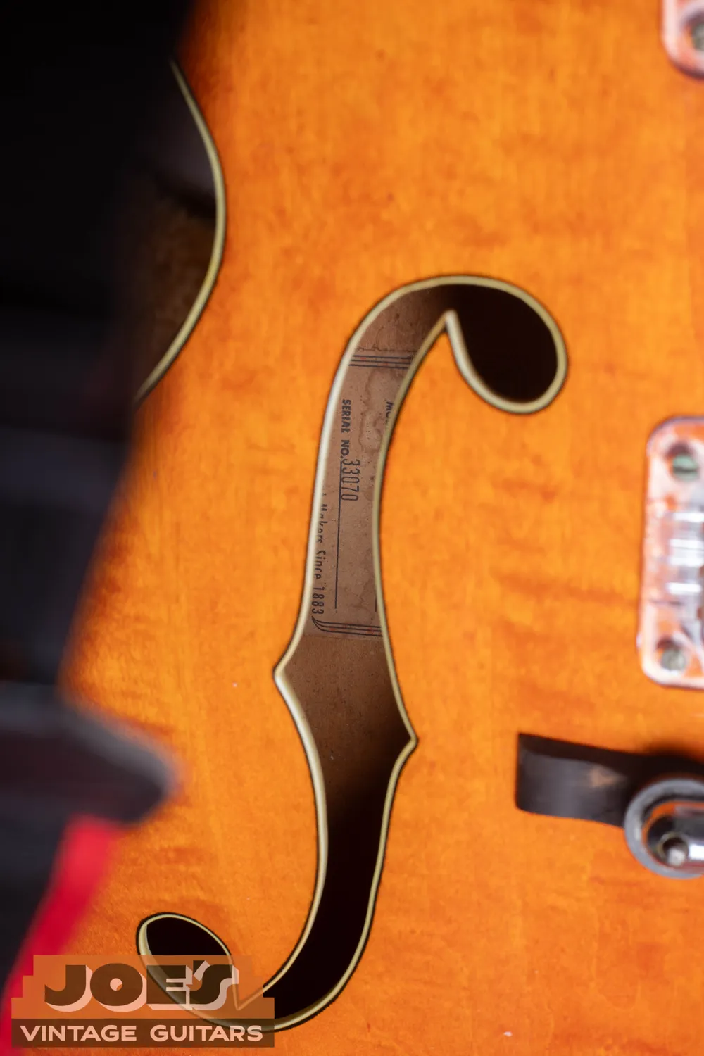 Orange Gretsch label viewed through an orange 6120 f-hole