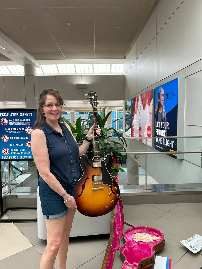 Sylvia’s daughter holding the 1959 Gibson ES-335 at the airport
