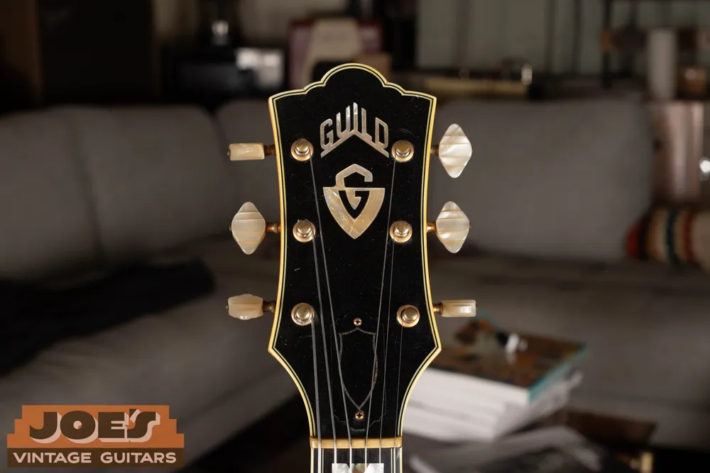 Guild X500 headstock with shield emblem and decorative inlays