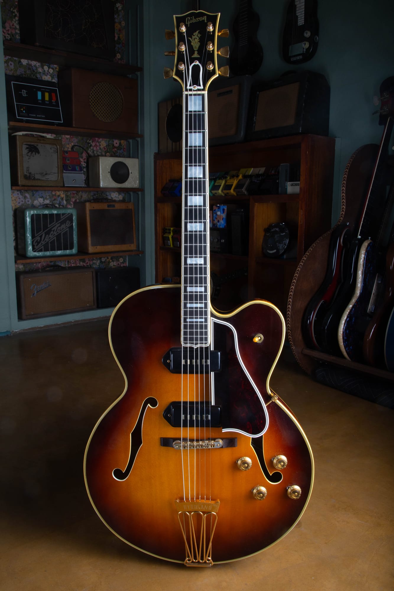 Full front of a 1957 Gibson Byrdland thinline archtop in sunburst with gold hardware, standing upright