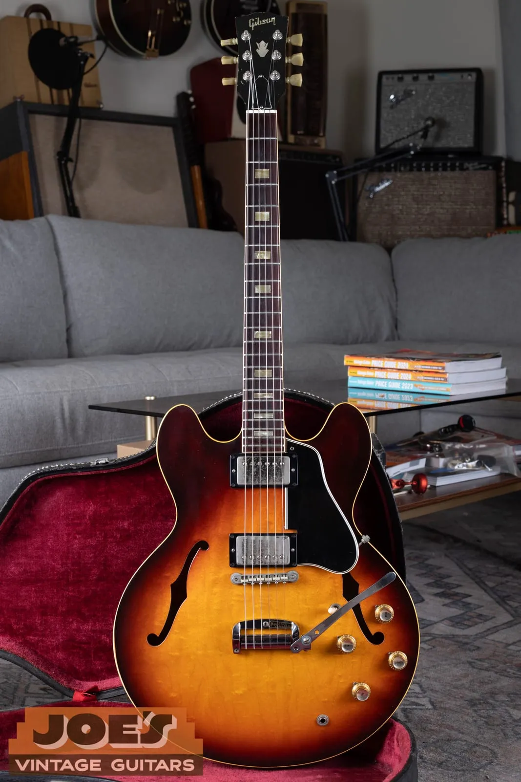 Full front view of a sunburst 1965 Gibson ES-335 standing in its case
