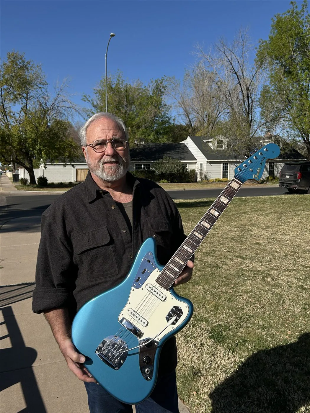 Bill holding the Lake Placid Blue 1966 Fender Jaguar his father bought for him when he was young