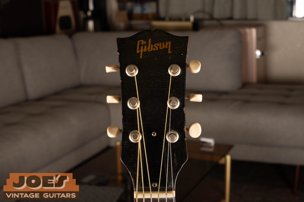 Close-up of a vintage Gibson gold block logo on a black headstock, a primary identifier for dating Gibson J-45 and J-50 acoustic guitars from 1948 through the 1960s.