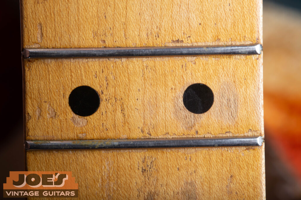 Close-up of a 1952 Fender Telecaster maple fretboard showing the wide 1.125-inch spacing of the black 12th fret position dots.