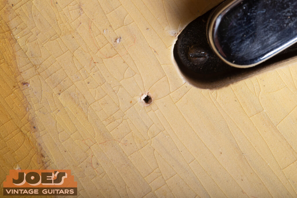 Alt TextOriginal 1952 Fender Telecaster body showing a tiny factory nail hole under the pickguard area.