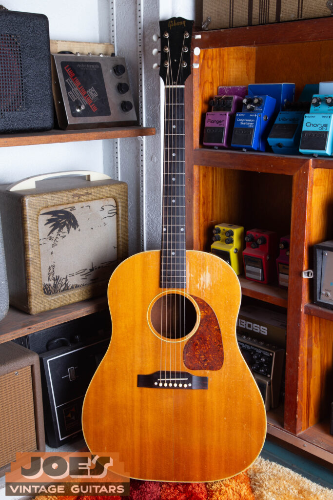 Full shot of a 1952 Gibson J-50 natural finish acoustic guitar featuring a small teardrop pickguard and belly-up bridge at Joe’s Vintage Guitars