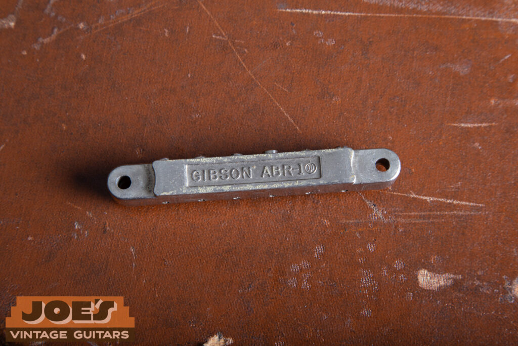 Macro close-up of the underside of an original nickel-plated ABR-1 Tune-o-matic bridge, showing the "ABR-1" stamp and the absence of a retainer wire.