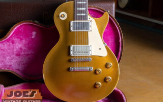 A comprehensive view of an original 1957 Gibson Les Paul Standard, highlighting the iconic bullion gold top and dual PAF humbucking pickups.