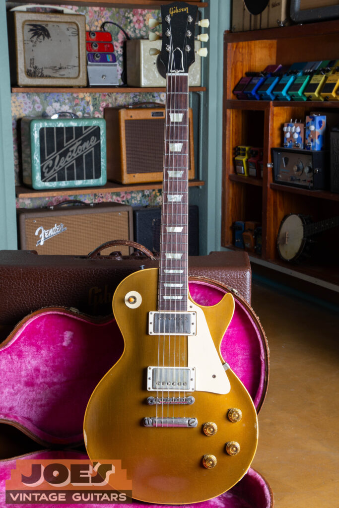 A full-length front view of an original 1957 Gibson Les Paul Standard, showcasing the iconic bullion gold top, dual nickel-covered PAF humbuckers, and the classic single-cutaway mahogany body design.