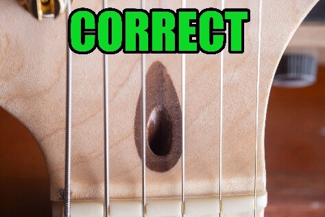 Authentic Fender truss rod walnut plug variation showing correct dark wood ring — valid USA Fender factory identifier distinguishing genuine from counterfeit necks