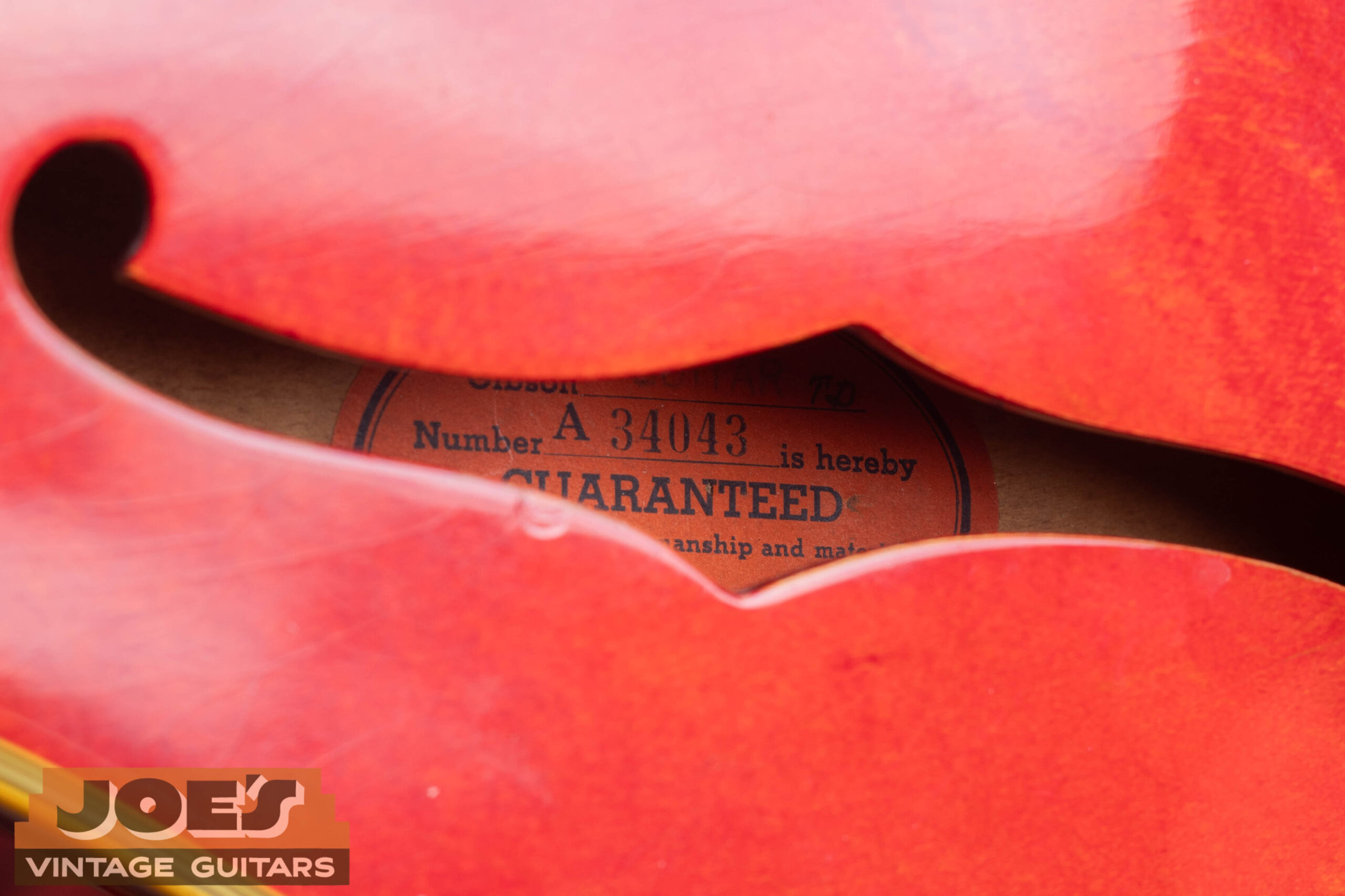 Vintage Gibson orange oval label showing A-prefix serial number used on Gibson guitars from 1947 through 1961