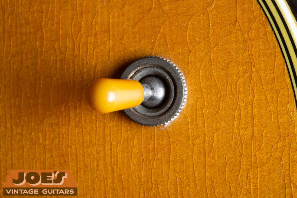 Close-up of the vintage 3-way toggle switch and control knobs on a factory-original 1958 Martin D-18E acoustic-electric guitar.