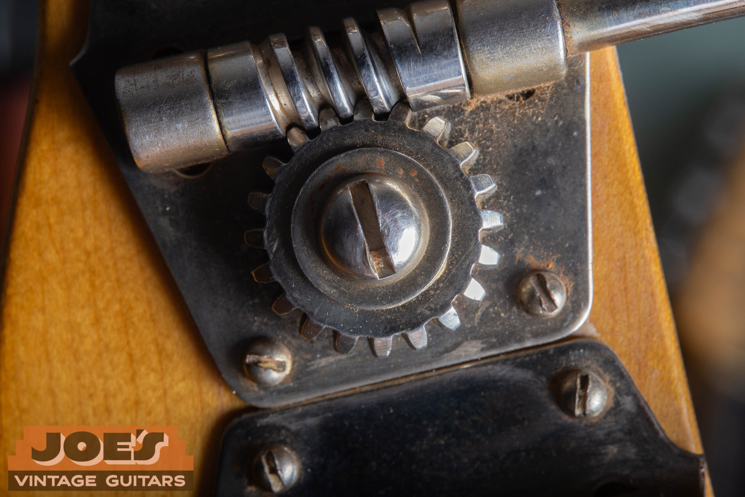 Original open-gear tuning machine on a 1952 Fender Precision Bass showing large flat metal button and four slotted mounting screws