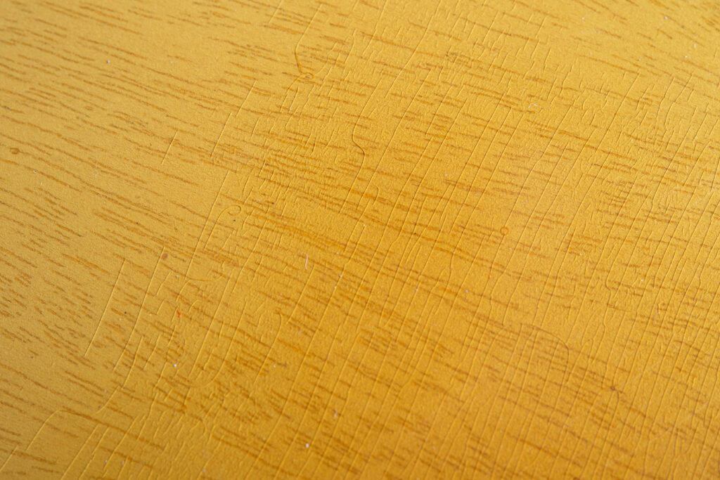 Close-up of a 1956 Gibson Les Paul Special in TV Yellow showing authentic "limed mahogany" finish. Detailed view of fine nitrocellulose lacquer weather checking, translucent wheat-colored tint, and white grain filler telegraphing through the mahogany body.