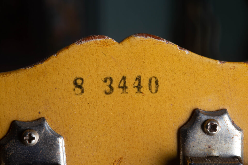 Detailed view of the back of a 1958 Gibson Les Paul Special headstock featuring the original black ink-stamped serial number. The Five-digit sequence is applied on top of the "TV Yellow" nitrocellulose finish, showing a distinct, slightly fuzzy edge characteristic of 1950s factory stamping rather than a modern impression into the wood.