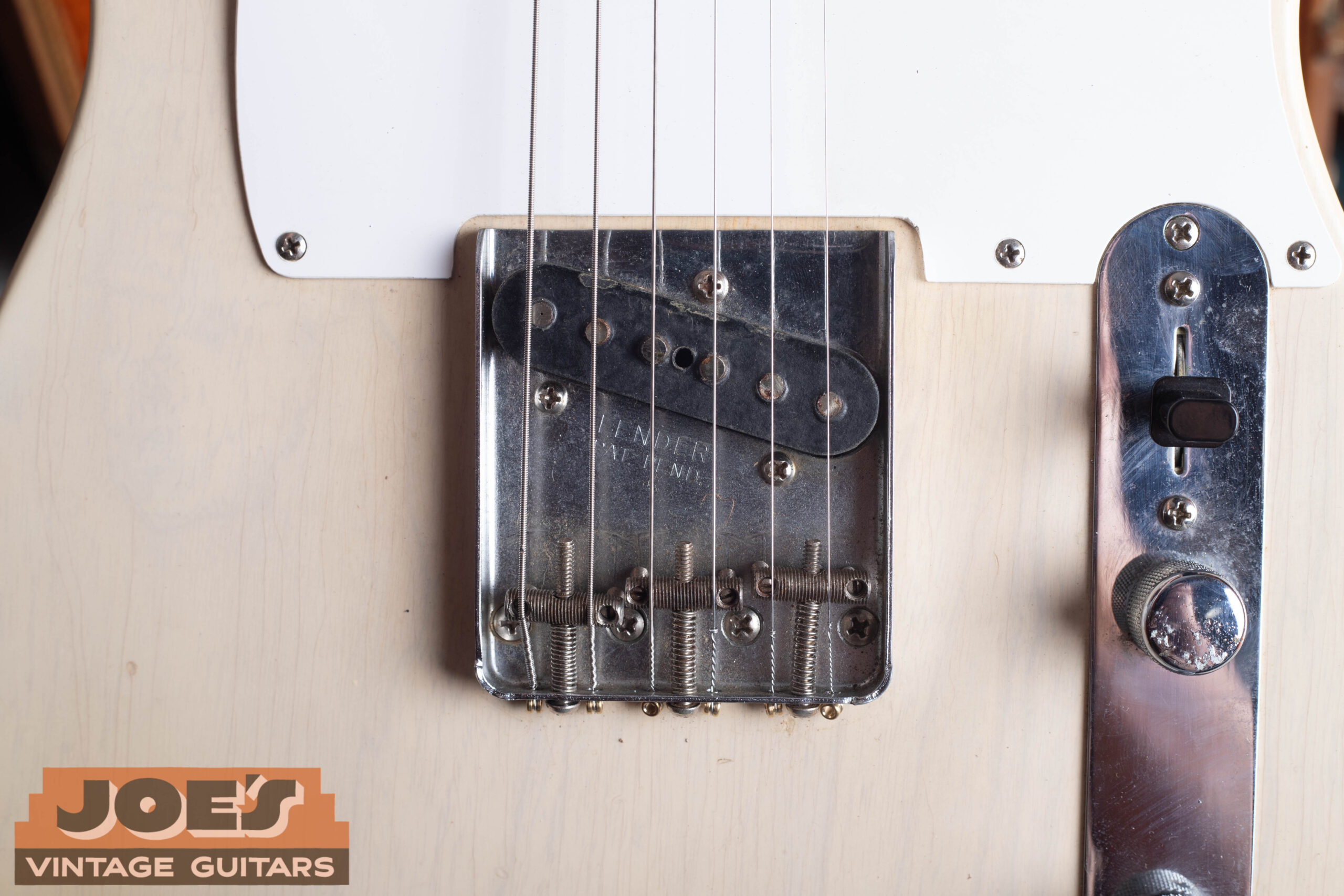 1959 Fender Telecaster bridge close-up showing threaded steel saddles, chrome ashtray bridge plate, and period-correct hardware
