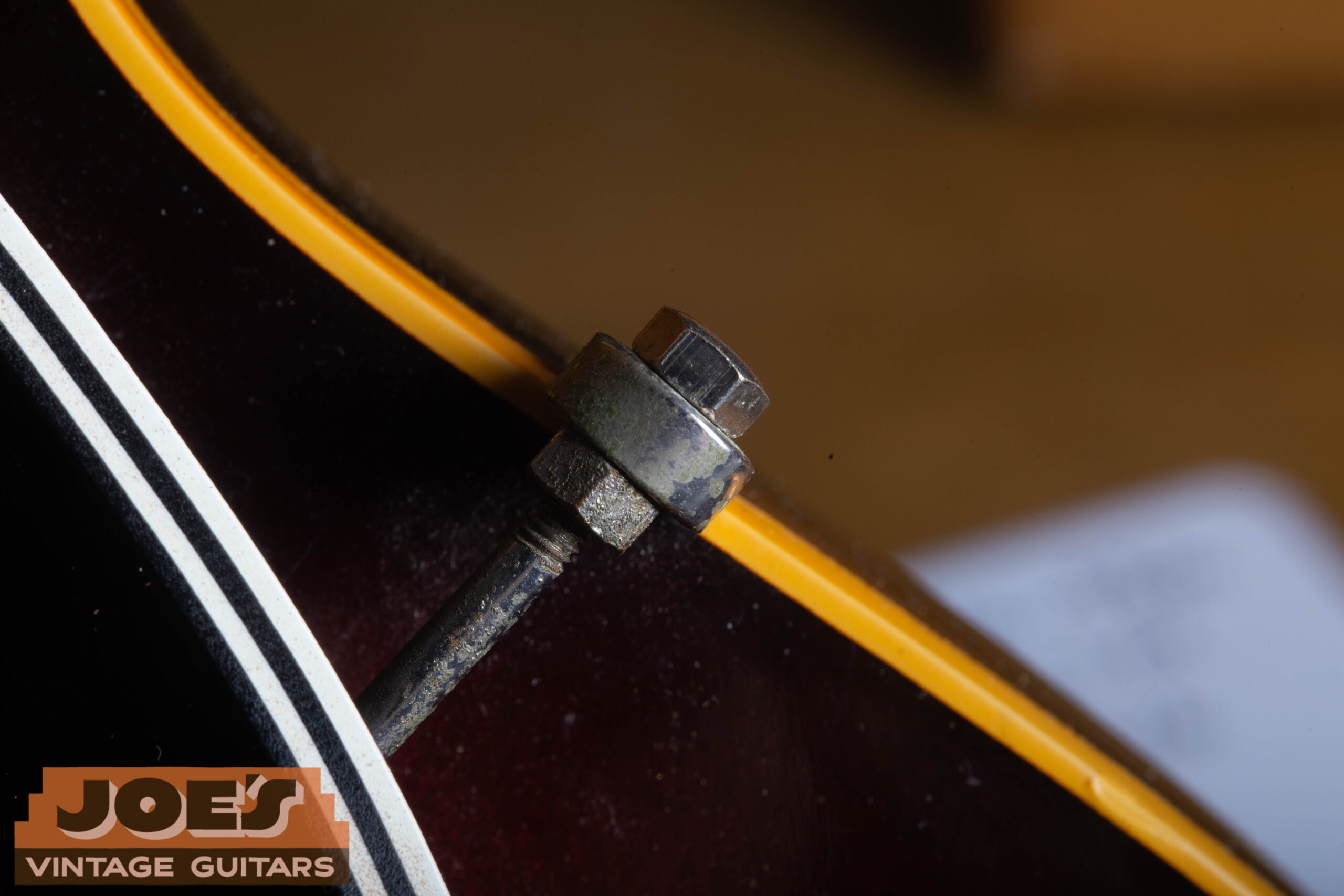Pickguard mounting bracket detail on a 1959 Gibson ES-330 — single-arm nickel bracket extending from the neck pickup area